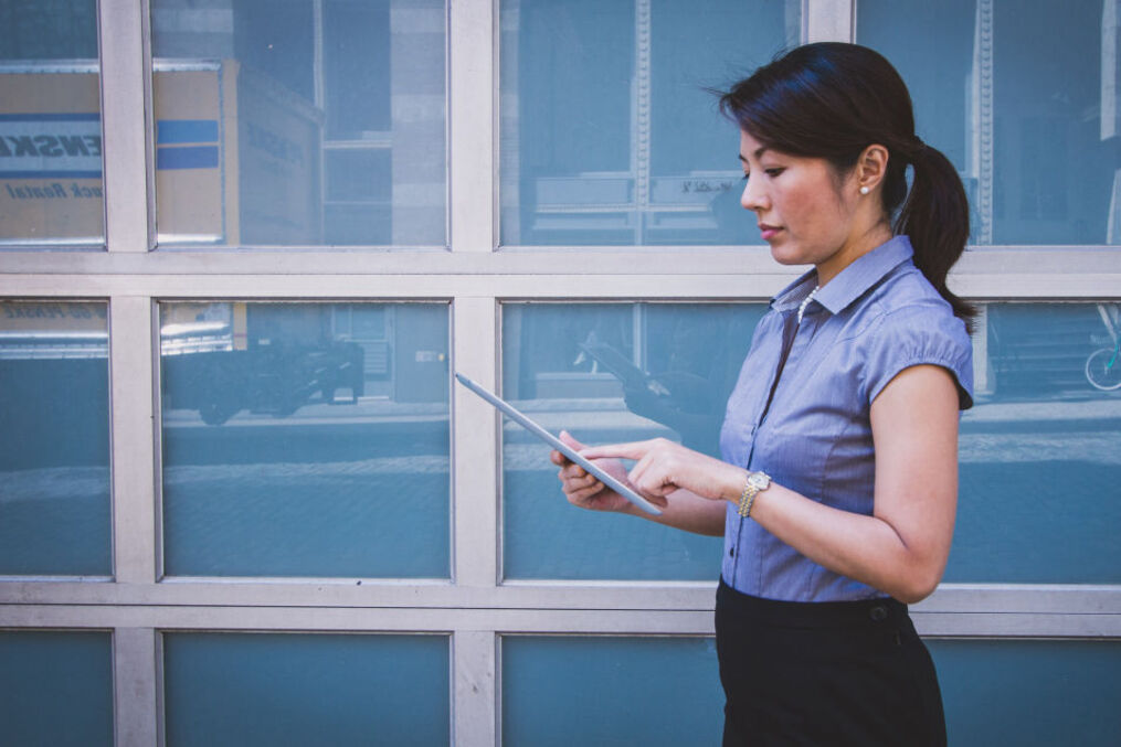 Woman analysing physical package delivery process and taking notes on tablet